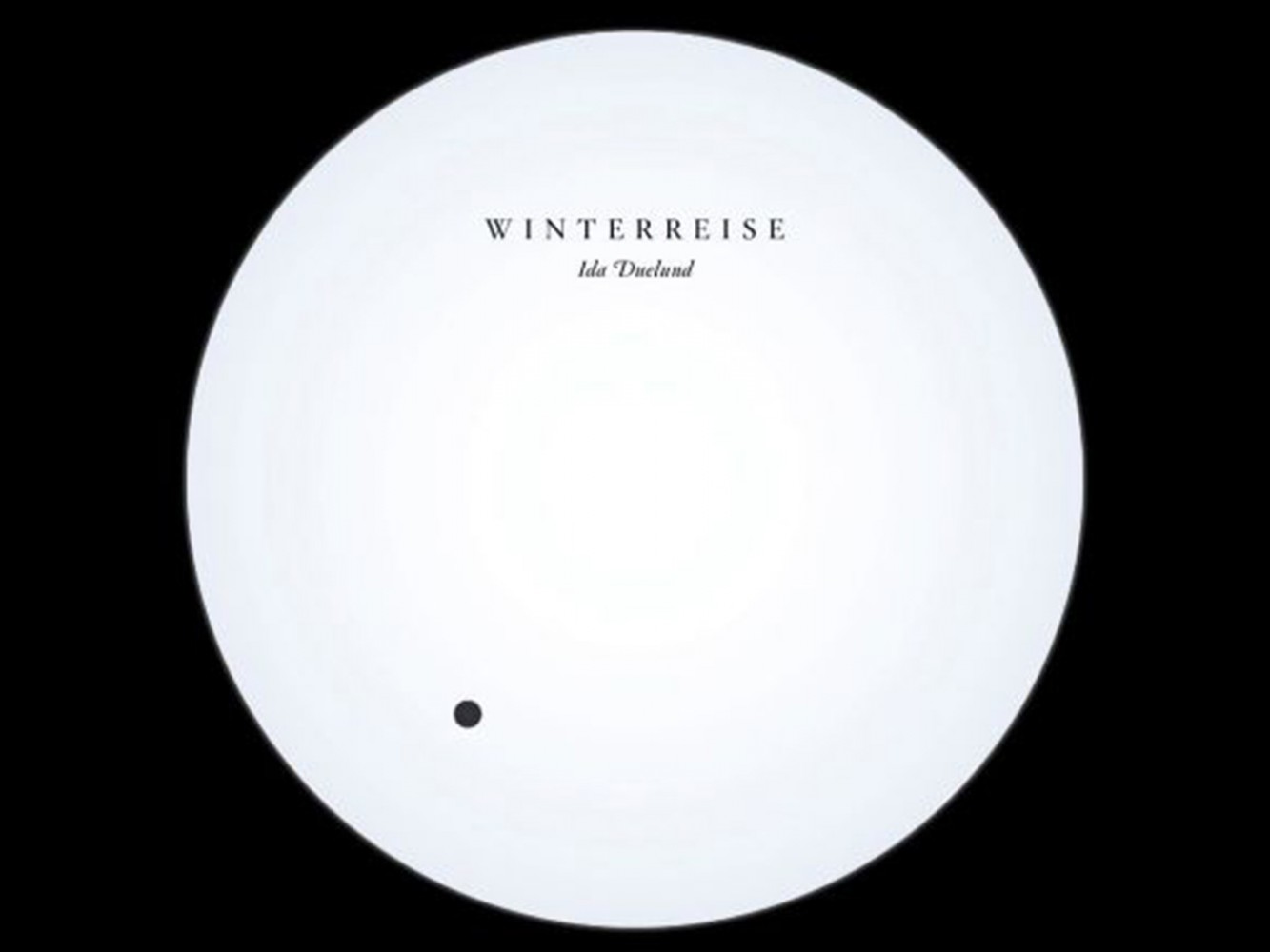 Promo image: a white circle with the words Winterreise Ida Dueland on it set against a black background