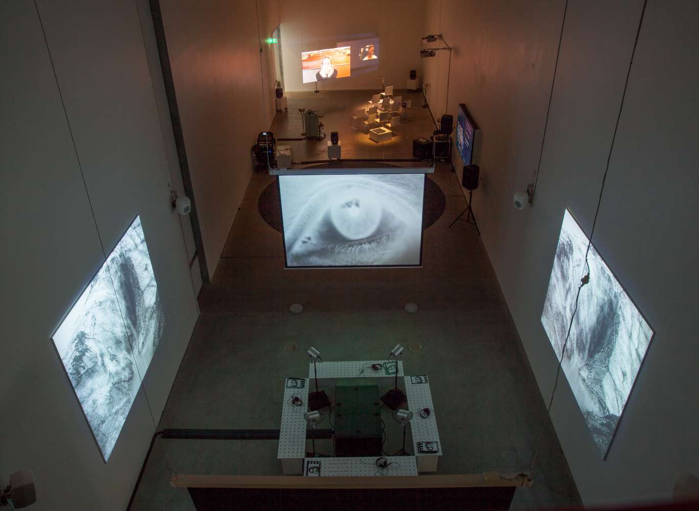 An arial view of an exhibition with screens and headphones.