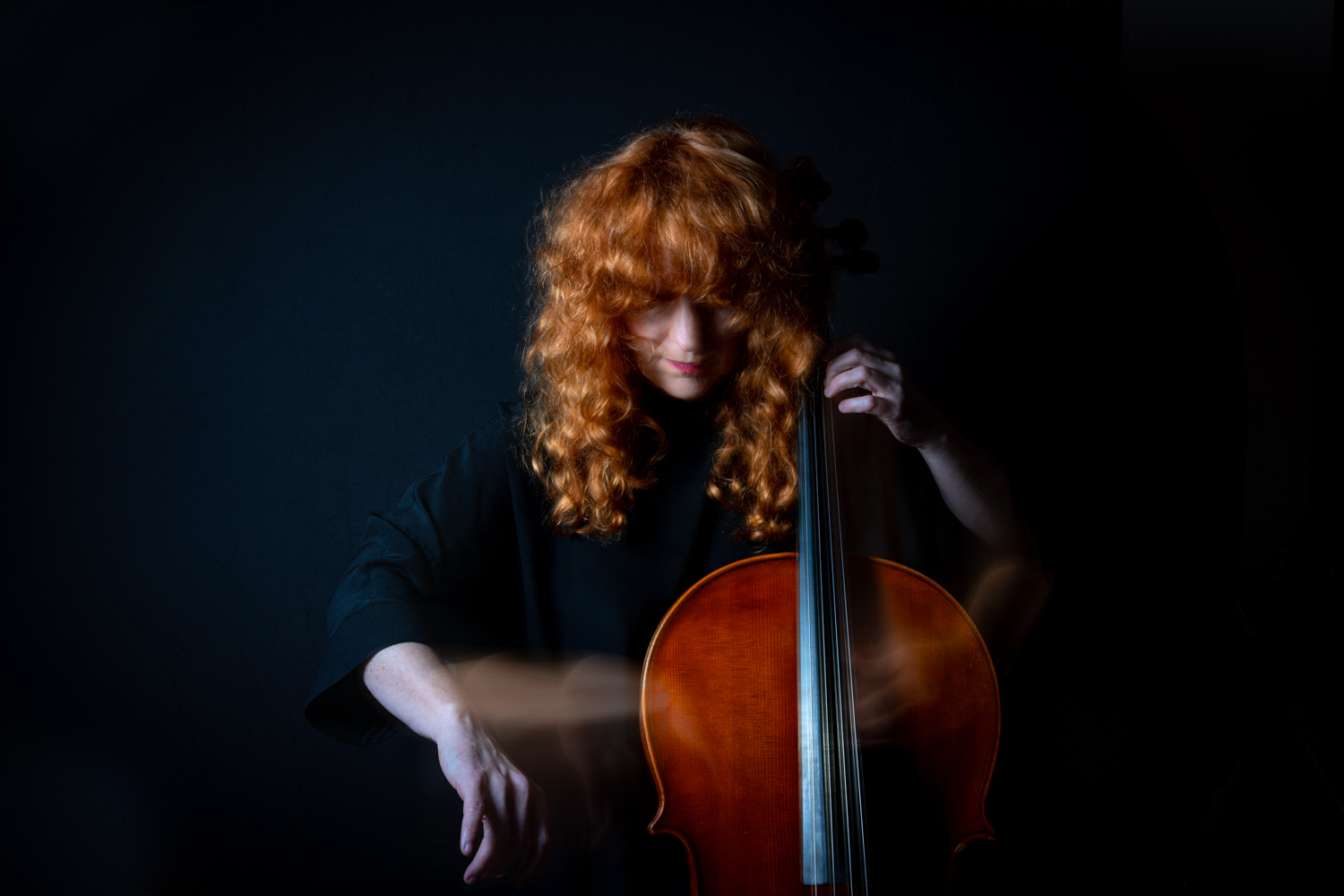 A red headed woman plays a cello